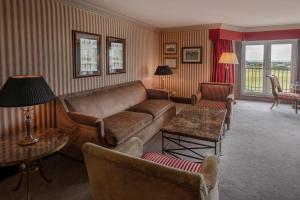 a living room with a couch and tables and chairs at Old Course Hotel St Andrews in St. Andrews