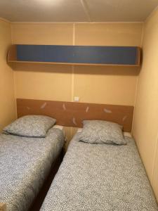 two twin beds in a small room with at Mobile-Home 1 "Ognon" in Pesmes