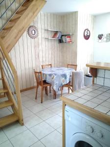 een keuken met een tafel en stoelen en een trap bij petite maison port de saint goustan in Auray