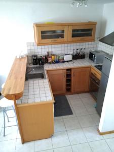 een keuken met houten kasten en een aanrechtblad bij petite maison port de saint goustan in Auray