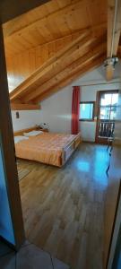 a bedroom with a bed in a room with wooden ceilings at Mansarde in Cornaiano