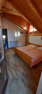 a large bed in a room with a wooden floor at Mansarde in Cornaiano