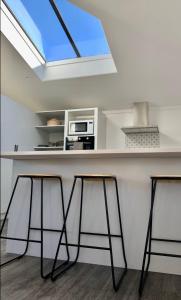 a kitchen with a counter with two stools and a window at Lakeview Oasis in Queenstown