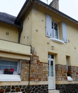 une maison avec des fenêtres et des fleurs dans les fenêtres dans l'établissement Pony Sweet Home, à Caen