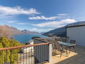 a balcony with a table and chairs and a view of a lake at Lakeview Oasis in Queenstown