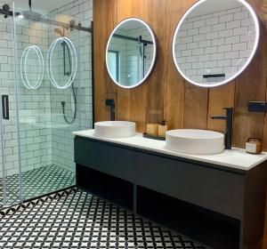 a bathroom with two sinks and two mirrors at Lakeview Oasis in Queenstown