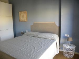 a bedroom with a bed with a white bedspread at Petra Magica in San Pantaleo