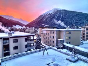 vistas a una ciudad con edificios cubiertos de nieve y una montaña en Apartment Bellania, en Davos