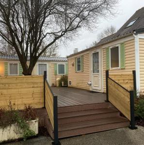 eine Holzterrasse vor einem Haus in der Unterkunft Mobil-Home 2 "Camping" in Pesmes