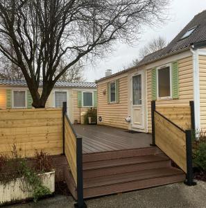 a wooden deck in front of a house at Mobil-Home 2 "Camping" in Pesmes
