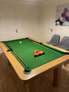 a pool table with balls on top of it at Bescot House Bramble Hill Bude 4 bed det house in Bude