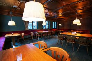 a restaurant with wooden tables and chairs and lights at Hotel Rosanna by Alpeffect Hotels in Sankt Anton am Arlberg