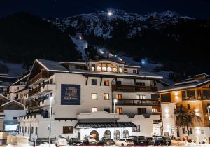 a large building with cars parked in front of it at Hotel Rosanna by Alpeffect Hotels in Sankt Anton am Arlberg