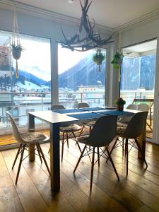 a dining room table with chairs and a large window at Apartment Bellania in Davos
