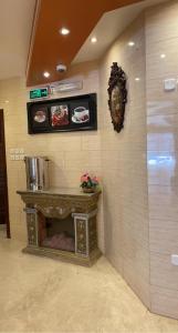 a living room with a fireplace in a wall at أجــنــحــة وتــيــن in Al Madinah