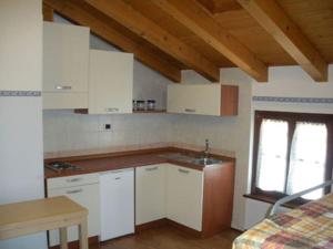 una cucina con armadi bianchi e un lavandino in camera di Al Benandant a Cormòns
