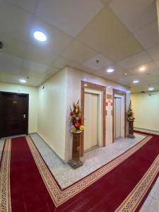 a room with a hallway with a door and a red carpet at أجــنــحــة وتــيــن in Al Madinah