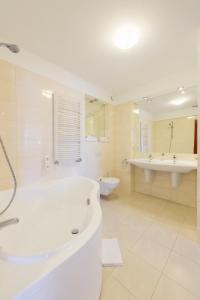 Duża biała łazienka z wanną i umywalką w obiekcie Hotel Rubin w Łodzi