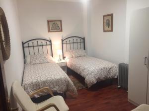 een slaapkamer met 2 bedden en een stoel. bij Apartamento en el Centro de Sevilla in Sevilla