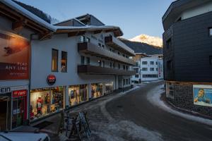 a street in a town with a mountain in the background at Hotel Gabl by Alpeffect Hotels in Sankt Anton am Arlberg