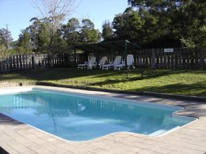 una piscina en un patio con sillas y una valla en Lakes Bushland Caravan & Lifestyle Park en Nicholson