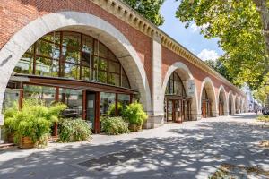 a brick building with arches on a street at Luxury Studio Daumesnil Wifi & Netflix in Paris