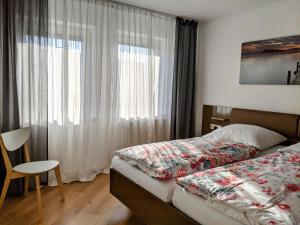 a bedroom with a bed and a window and a chair at Cozy Apartment with Parking Garage near Outlet in Metzingen
