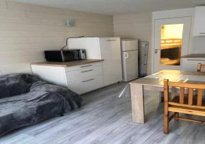 cocina con cama, mesa y nevera en Studio cabine 4 personnes - Résidence Les Artigalas, en Barèges