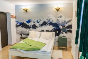 a bedroom with a wall mural of mountains and clouds at Pensiunea Luna in Buşteni