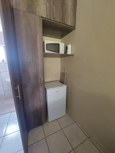 a kitchen with a small refrigerator and a microwave at DeLutz Overnight Room 3 in Polokwane