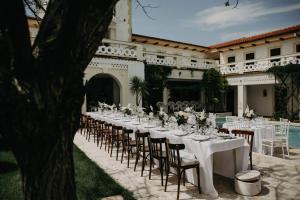 a long table with white tables and chairs in front of a building at Villa Pontica in Mamaia Sat/Năvodari