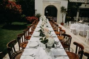 a long table with white plates and flowers on it at Villa Pontica in Mamaia Sat/Năvodari +93 photos