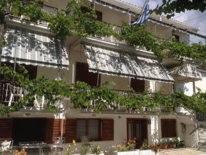 a building with a lot of windows and plants at Dimitris Rooms in Vlikhón
