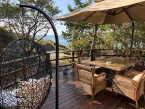 沼津的住宿－遙かな亭，木甲板配有桌子和遮阳伞