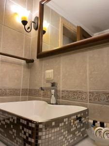 a bathroom with a bath tub and a mirror at Piccolo Mondo Hotel in Ağva