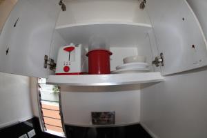 een keuken met witte kasten en een rode blender bij Logan Apartments in Bantayan