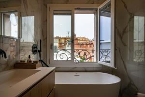 a bathroom with a bath tub and a window at PANORAMA APARTMENT in Bologna