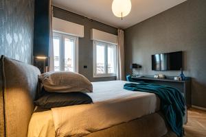 a bedroom with a bed with pillows and a television at PANORAMA APARTMENT in Bologna