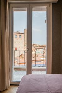 een slaapkamer met een deur naar een balkon bij PANORAMA APARTMENT in Bologna