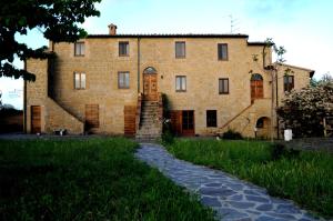 a large brick building with a path in front of it at Agriturismo Naioli in Pitigliano