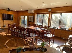 une salle à manger avec une grande table et des chaises en bois dans l'établissement 遙かな亭, à Numazu