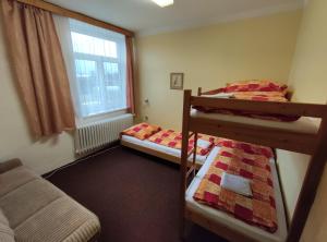 a bedroom with two bunk beds and a window at Penzion KUDLIK in Rudná pod Pradědem