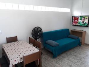 a living room with a blue couch and a table at Recanto do Dan - Praia Picarras- Beto Carrero in Piçarras