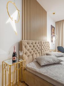a bedroom with a king sized bed with a gold side table at Vida Herastrau, luxury 2 rooms apartment in Bucharest