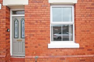 a red brick building with a white door and window at Cheerful two bedroom town house in Chester in Chester