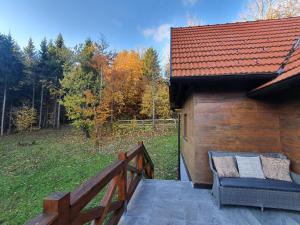 a wooden building with a bench on a deck at Starry Laz mountain house in Ravna Gora