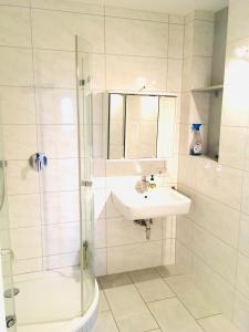 a white bathroom with a sink and a shower at Ganzes Apartment 20 min vom Frankfurt HBF in Langen