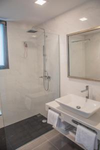 a white bathroom with a sink and a shower at Calamar Hotel in São Vicente