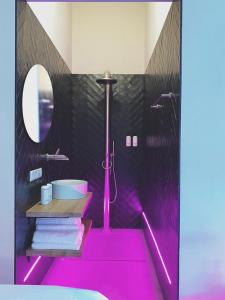 y baño con suelo de color rosa, ducha y lavamanos. en Home8 studio’s en Arnhem