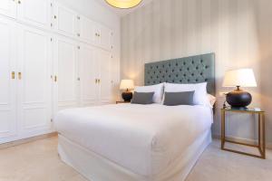 1 dormitorio blanco con 1 cama grande y 2 lámparas en Genteel Home Arfe Terrace, en Sevilla 27 fotos más